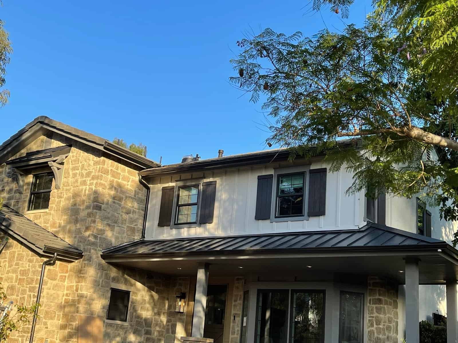 Elegant residential roof with metal and shingle roofing, showcasing durable materials and stylish design.